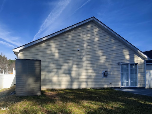 view of property exterior with fence and a yard