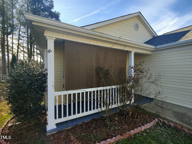 view of property exterior featuring covered porch and a shingled roof