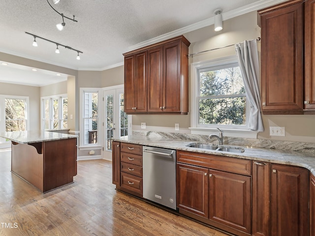 kitchen with light wood finished floors, crown molding, dishwasher, light stone counters, and a sink