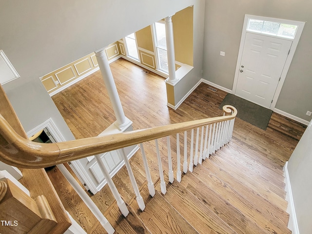 725 Littleleaf Ct, Holly Springs, NC 27540 - staircase featuring a decorative wall, wood finished floors, and ornate columns