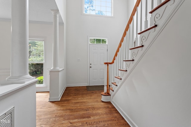 725 Littleleaf Ct, Holly Springs, NC 27540 - entryway featuring decorative columns, healthy amount of natural light, light wood finished floors, stairs, and a towering ceiling