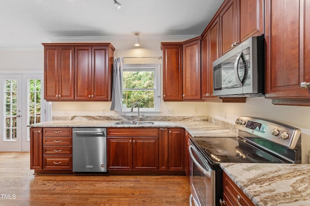725 Littleleaf Ct, Holly Springs, NC 27540 - kitchen featuring stainless steel appliances, light stone counters, ornamental molding, light wood-style flooring, and a textured ceiling
