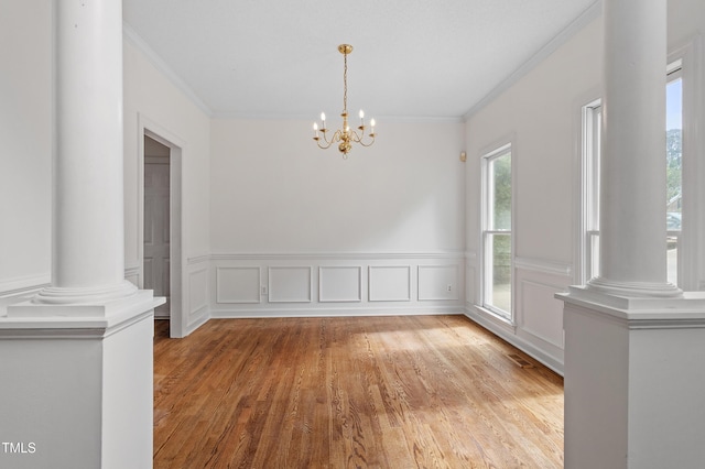 725 Littleleaf Ct, Holly Springs, NC 27540 - unfurnished dining area featuring ornamental molding, a chandelier, light wood finished floors, decorative columns, and wainscoting