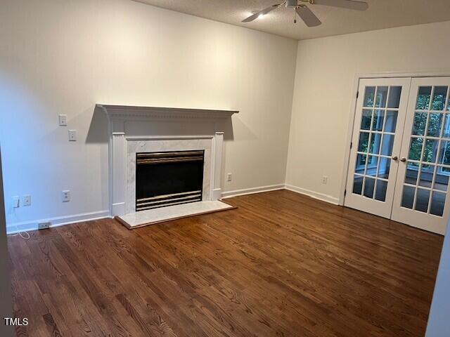 725 Littleleaf Ct, Holly Springs, NC 27540 - unfurnished living room featuring a ceiling fan, wood finished floors, french doors, and a fireplace
