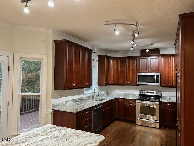 725 Littleleaf Ct, Holly Springs, NC 27540 - kitchen featuring stainless steel appliances, dark wood-style flooring, light stone countertops, and crown molding