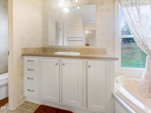 bathroom with toilet, tile patterned floors, a bathtub, and vanity