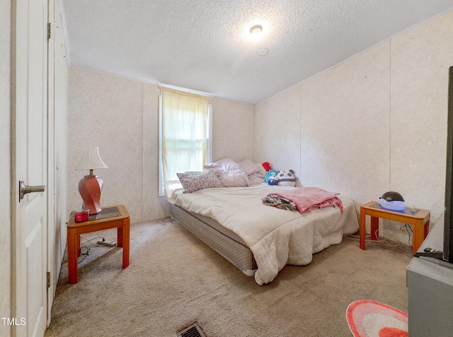 bedroom featuring a textured ceiling and light colored carpet