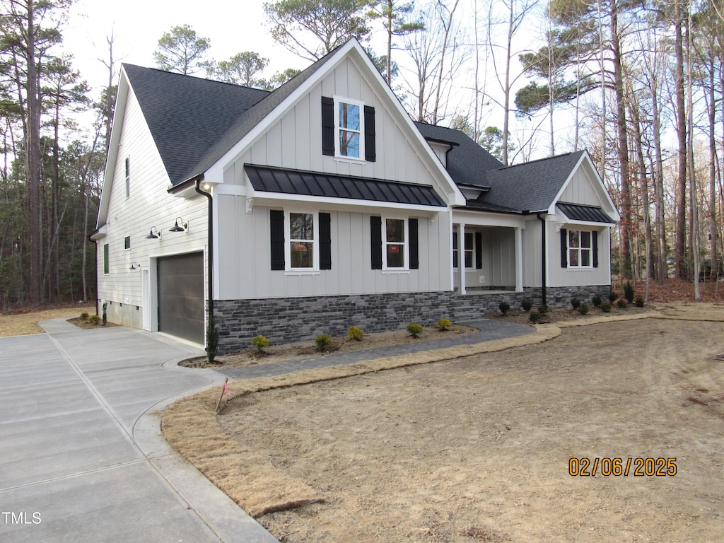 modern farmhouse style home featuring roof with shingles, a standing seam roof, and board and batten siding