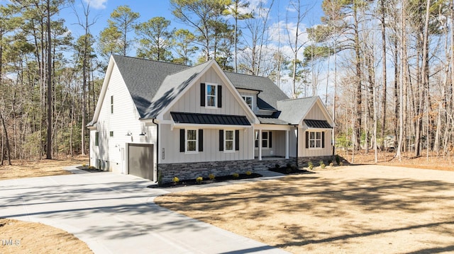 modern inspired farmhouse with metal roof, a shingled roof, driveway, board and batten siding, and a standing seam roof