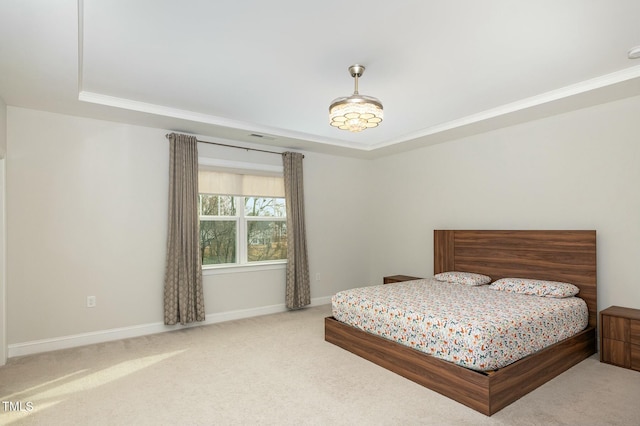 bedroom featuring a tray ceiling, ornamental molding, and light colored carpet