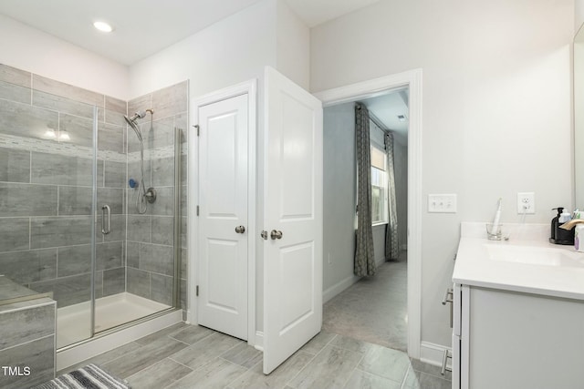 bathroom featuring vanity and a shower with door