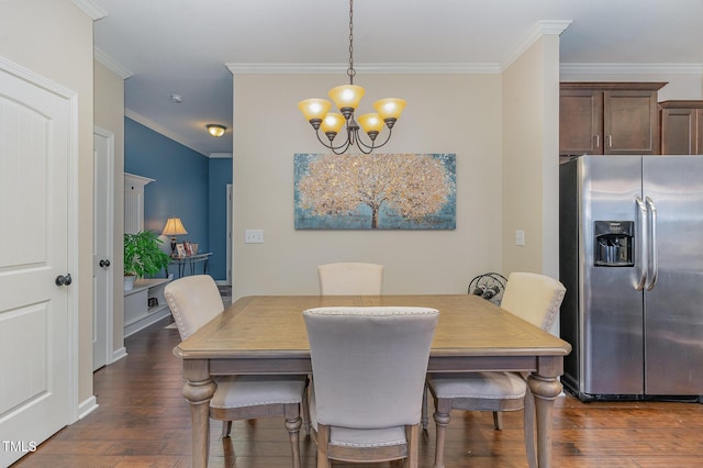 dining area with dark wood-type flooring, ornamental molding, and a chandelier