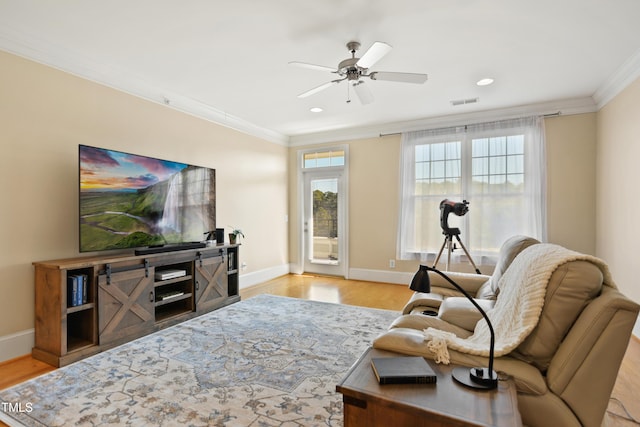 living area featuring crown molding, visible vents, ceiling fan, wood finished floors, and baseboards