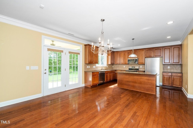 532 Front Ridge Dr, Cary, NC 27519 - kitchen featuring stainless steel appliances, dark wood-style floors, a chandelier, crown molding, and tasteful backsplash