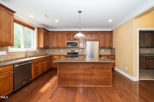 532 Front Ridge Dr, Cary, NC 27519 - kitchen with appliances with stainless steel finishes, dark wood-type flooring, crown molding, a kitchen island, and a sink