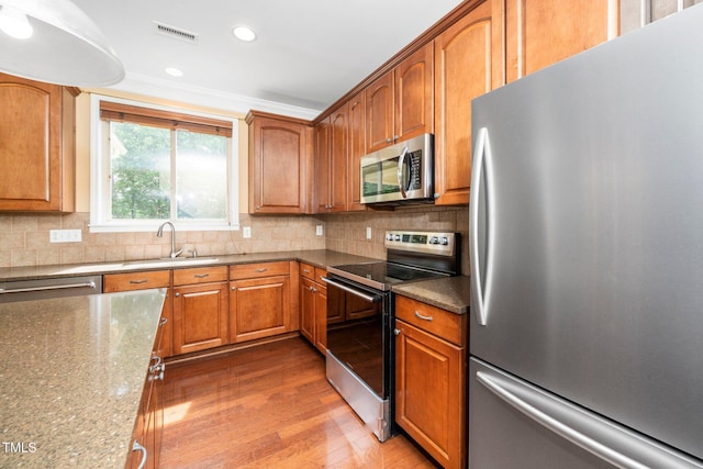 532 Front Ridge Dr, Cary, NC 27519 - kitchen featuring appliances with stainless steel finishes, a sink, wood finished floors, tasteful backsplash, and recessed lighting