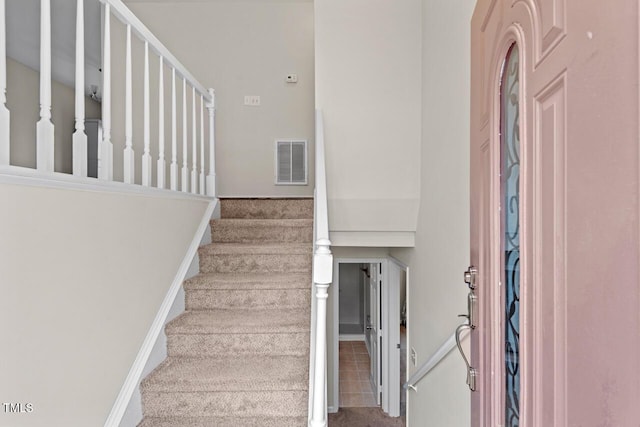 stairway with baseboards and visible vents