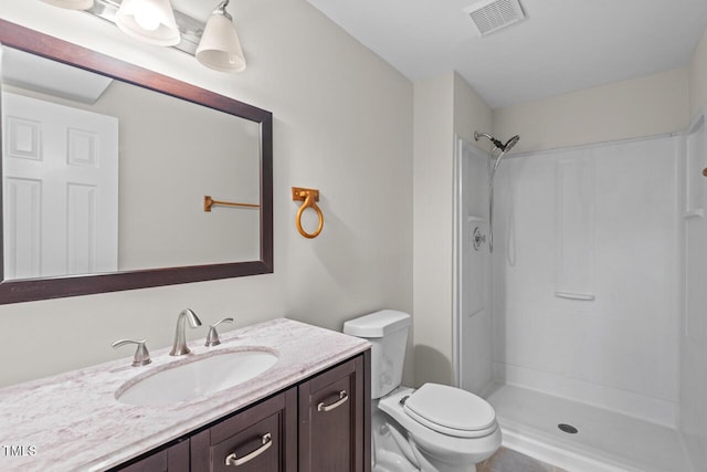 full bathroom featuring toilet, vanity, walk in shower, and visible vents