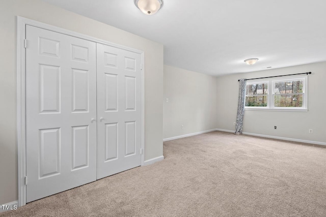 unfurnished bedroom with carpet floors, a closet, and baseboards