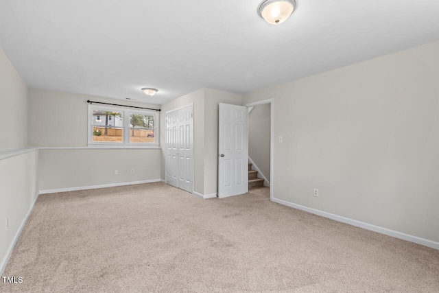 unfurnished bedroom featuring a closet, baseboards, and carpet flooring