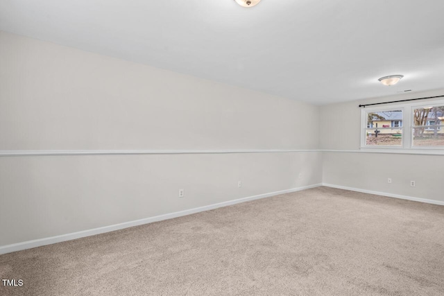 carpeted spare room with baseboards