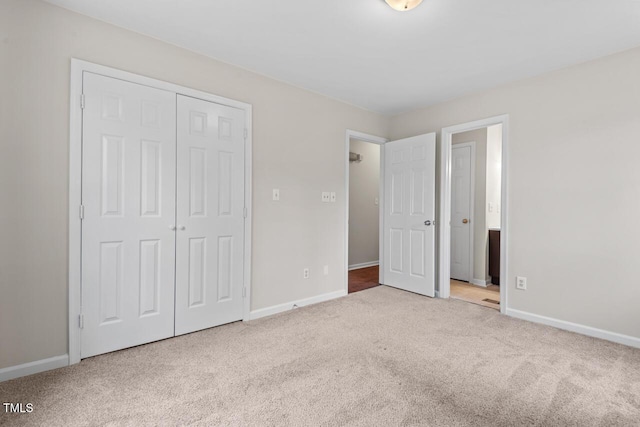 unfurnished bedroom with a closet, carpet flooring, and baseboards