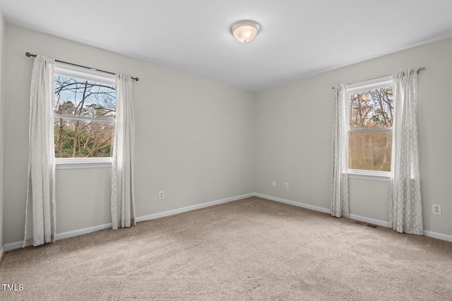 carpeted spare room featuring visible vents and baseboards