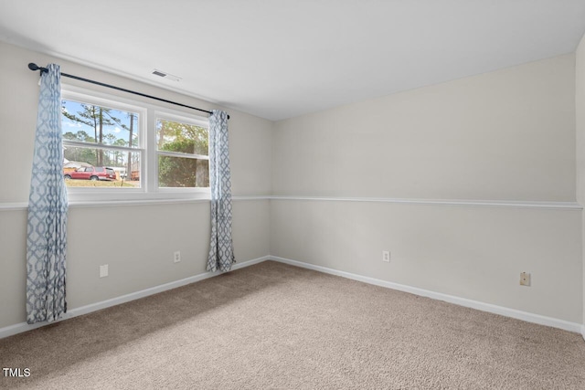 carpeted spare room with baseboards and visible vents