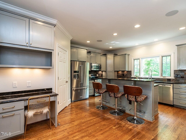 3504 Rock Creek Dr, Raleigh, NC 27609 - kitchen with crown molding, appliances with stainless steel finishes, gray cabinets, and a kitchen bar