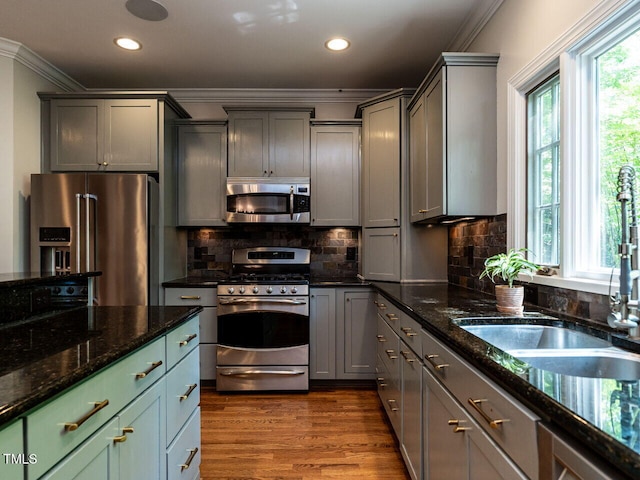 3504 Rock Creek Dr, Raleigh, NC 27609 - kitchen with crown molding, a sink, dark stone counters, stainless steel appliances, and recessed lighting