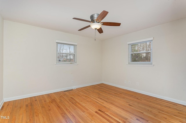 empty room with ceiling fan, baseboards, and light wood-type flooring