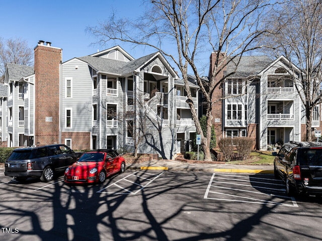 view of front facade with uncovered parking and brick siding