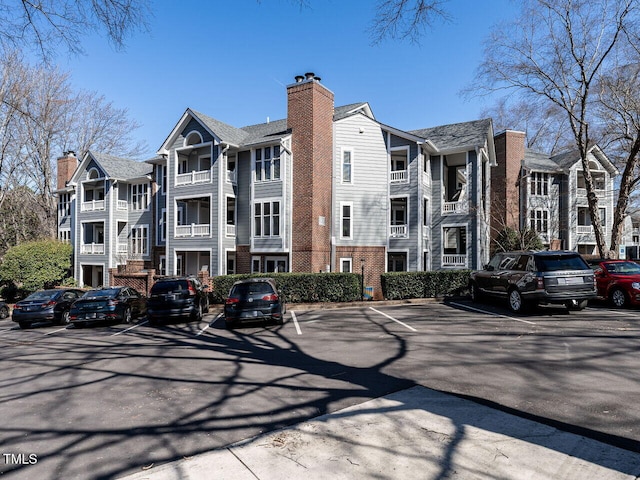 view of building exterior featuring uncovered parking and a residential view