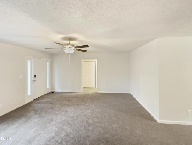 carpeted empty room with ceiling fan and a textured ceiling