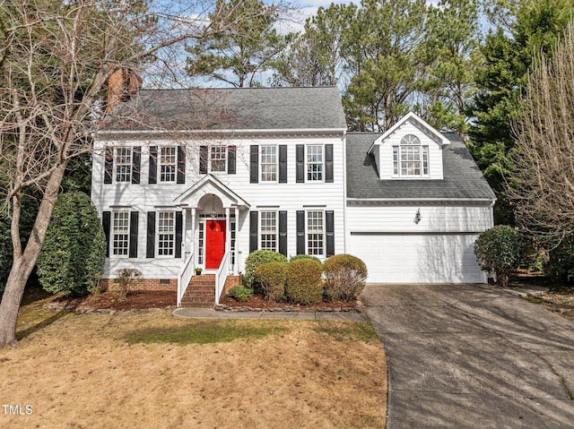 colonial inspired home with an attached garage, concrete driveway, crawl space, roof with shingles, and a front yard