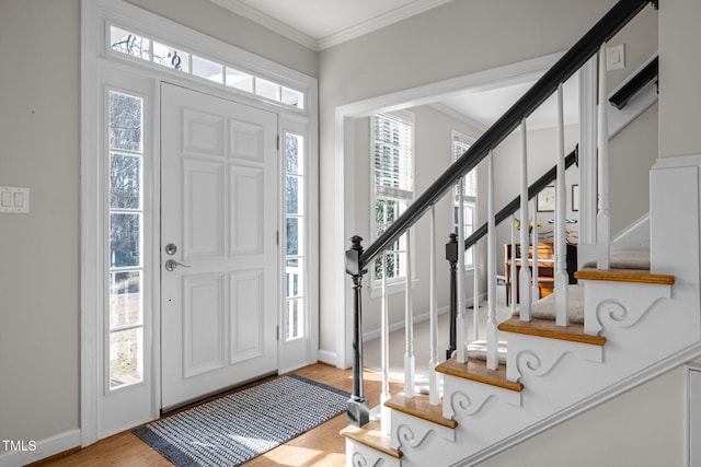 entryway featuring stairway, baseboards, crown molding, and wood finished floors