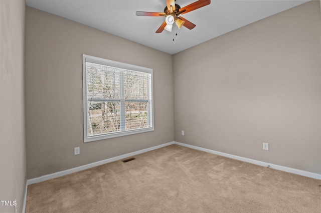 empty room featuring light carpet, ceiling fan, visible vents, and baseboards