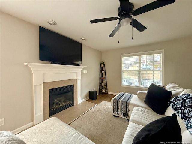 living room featuring ceiling fan and a tile fireplace