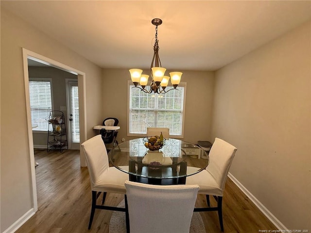 dining area with dark hardwood / wood-style flooring and a notable chandelier