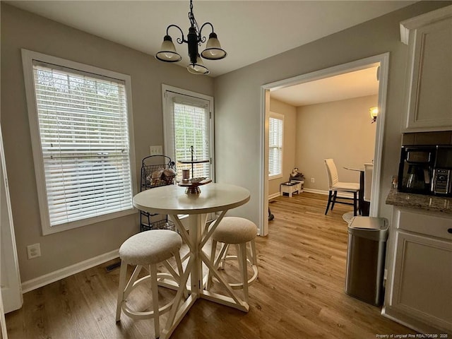 dining area with an inviting chandelier and light wood-type flooring