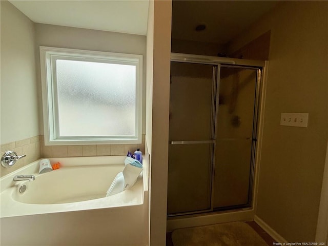 bathroom featuring shower with separate bathtub