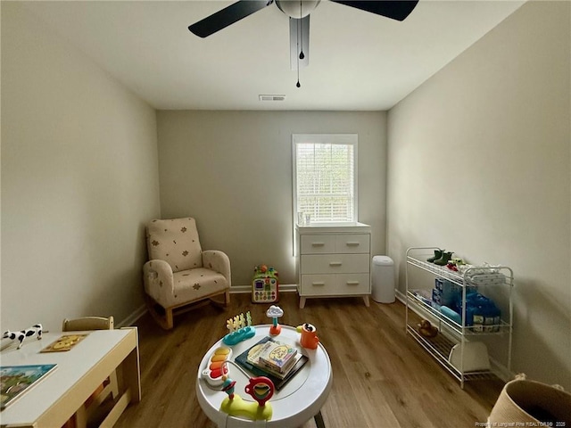 living area featuring ceiling fan and hardwood / wood-style floors