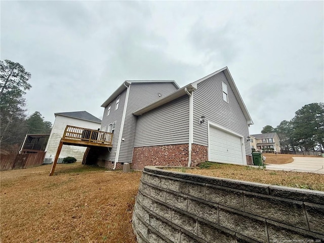 view of side of home featuring a garage and a lawn