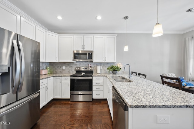 kitchen with backsplash, appliances with stainless steel finishes, white cabinetry, a sink, and a peninsula