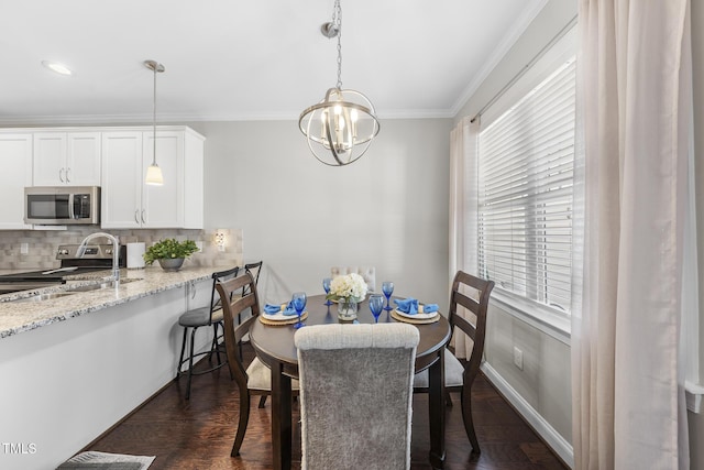 dining room featuring a chandelier, ornamental molding, dark wood-style floors, and baseboards