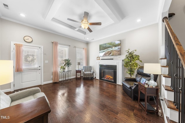 living room featuring baseboards, a glass covered fireplace, ceiling fan, hardwood / wood-style floors, and crown molding