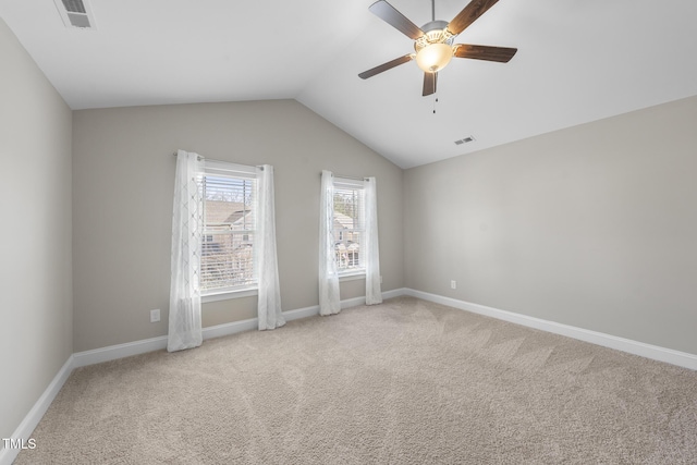 spare room with lofted ceiling, carpet, and visible vents