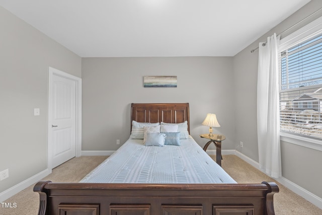 bedroom featuring light carpet and baseboards