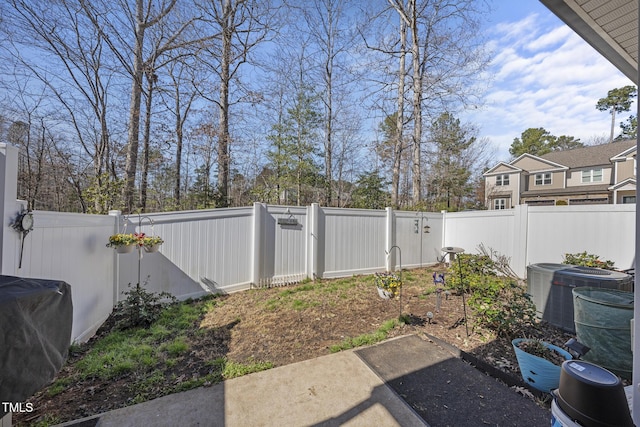 view of yard with a fenced backyard, a gate, and central AC