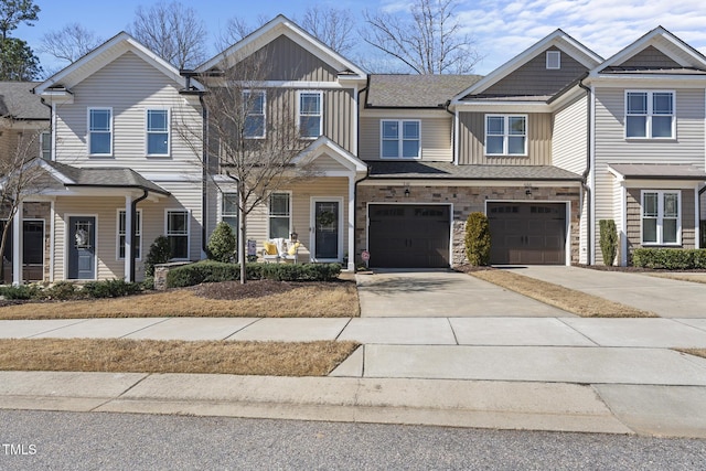 multi unit property with concrete driveway, stone siding, board and batten siding, and an attached garage